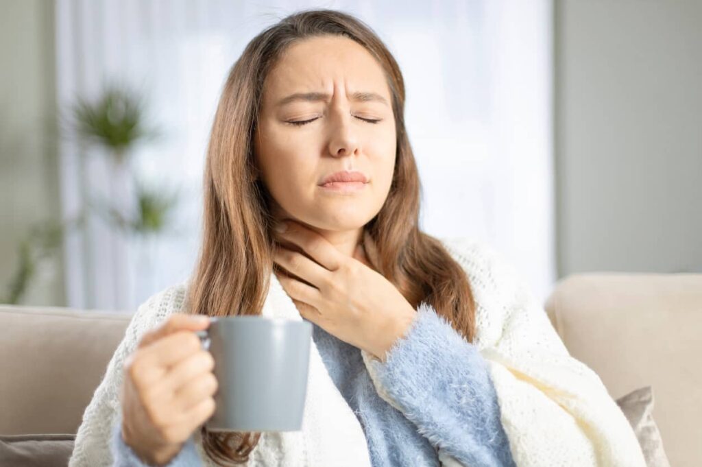 Gripe ou resfriado. Mulher com dor de garganta