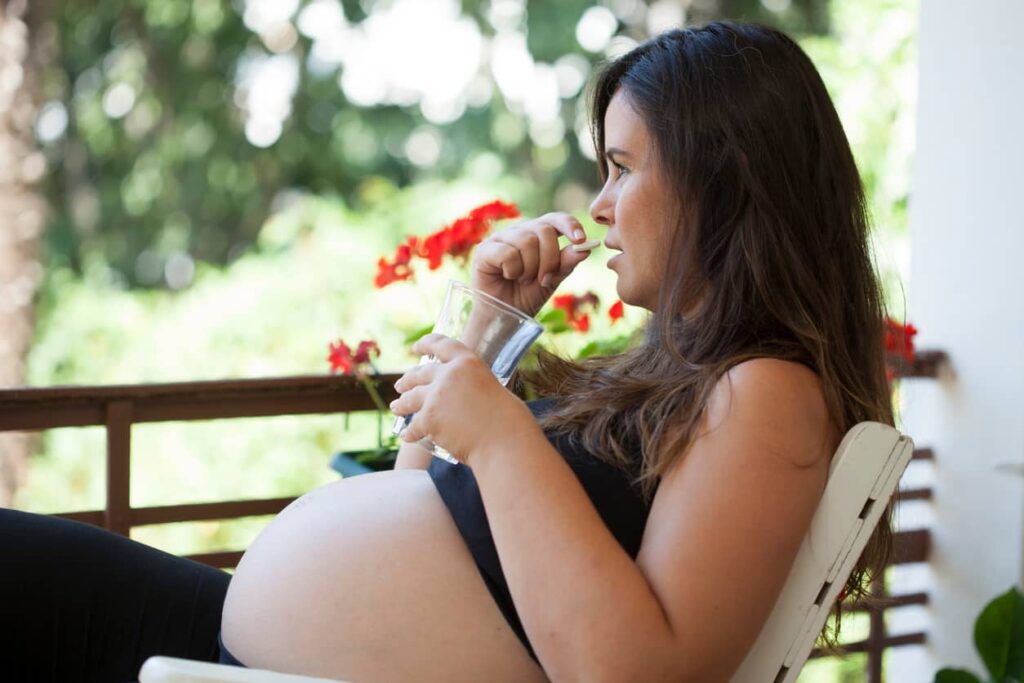 Mulher grávida toma vitamina