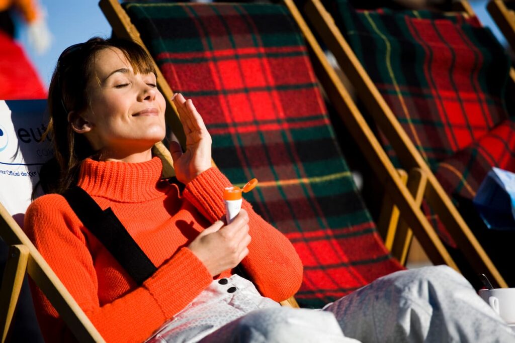 Bronzeada no inverno, mulher passa protetor solar