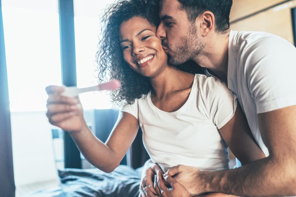 Fertilidade feminina, casal feliz com resultado do teste de gravidez