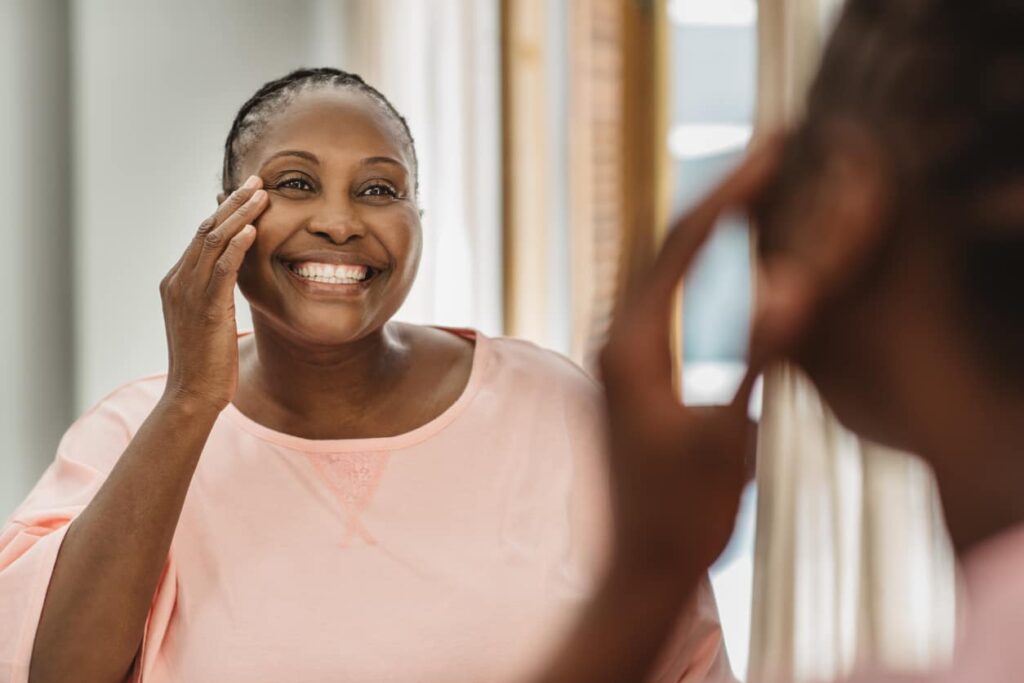 Colágeno verisol, mulher feliz se olha no espelho